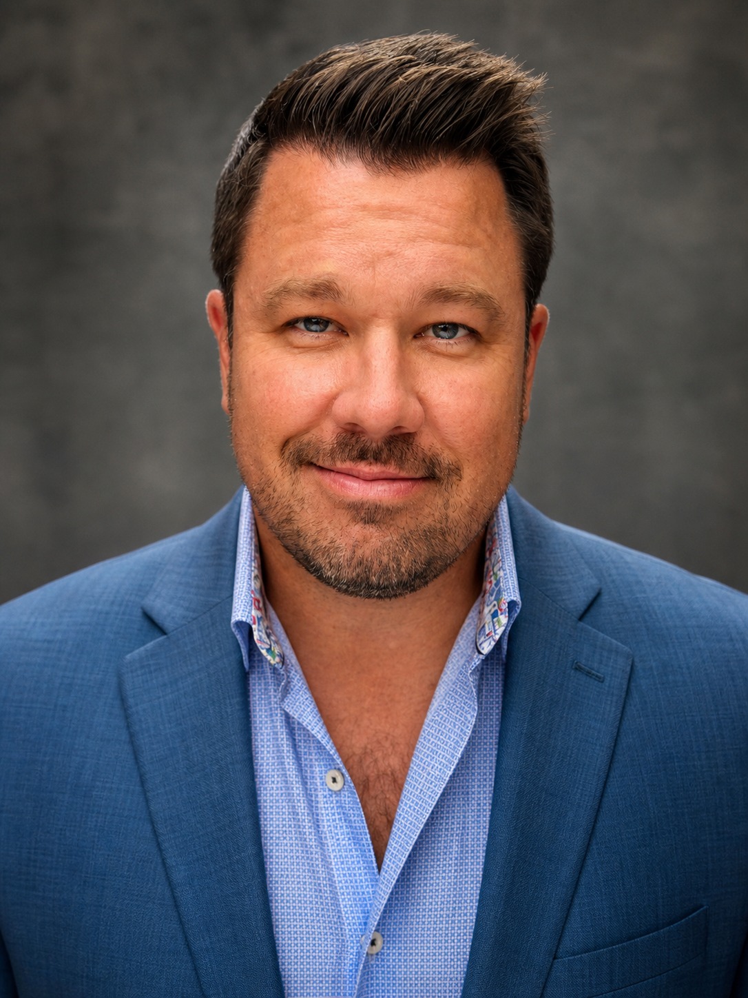 Studio portrait of Tim Calahan wearing a blue blazer